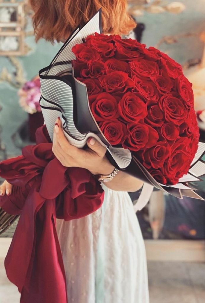 A LADY HOLDING A BIG BOUQUET