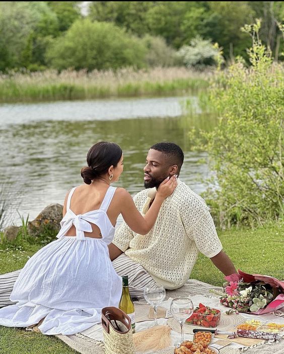 HAPPY COUPLE BY THE LAKE HAVING A PICNIC